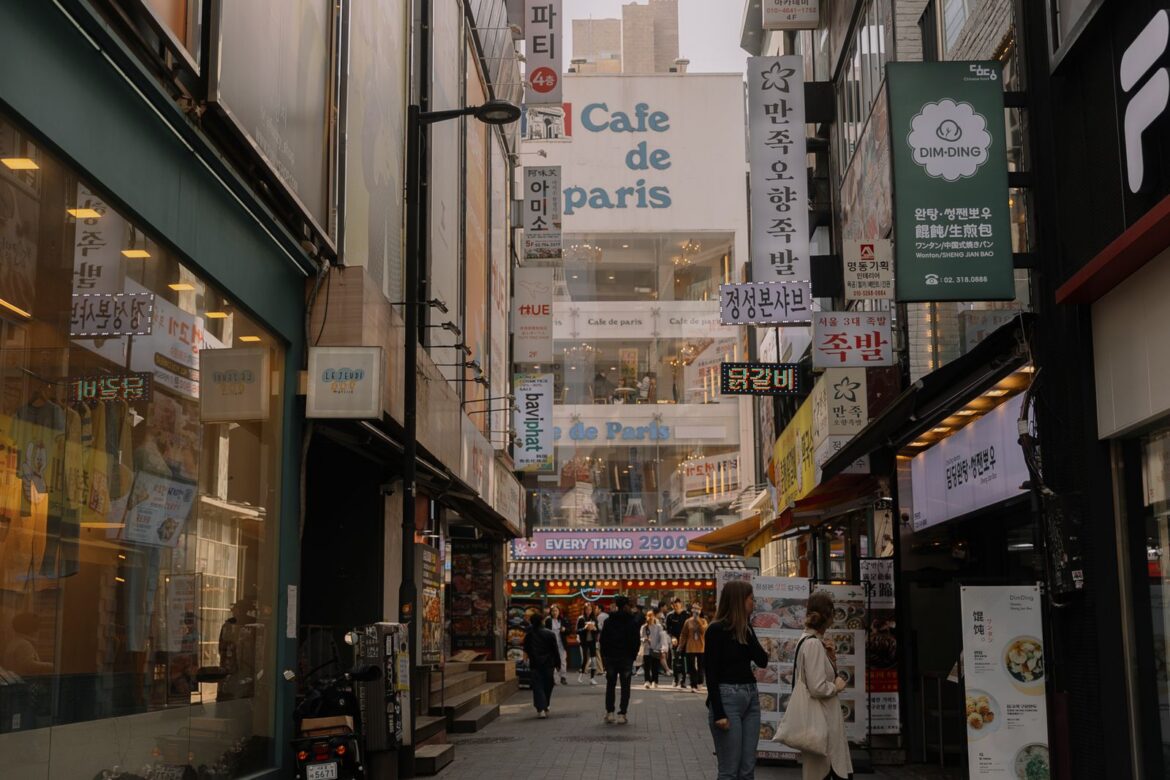 People in a Seoul alley with a cafe in the background