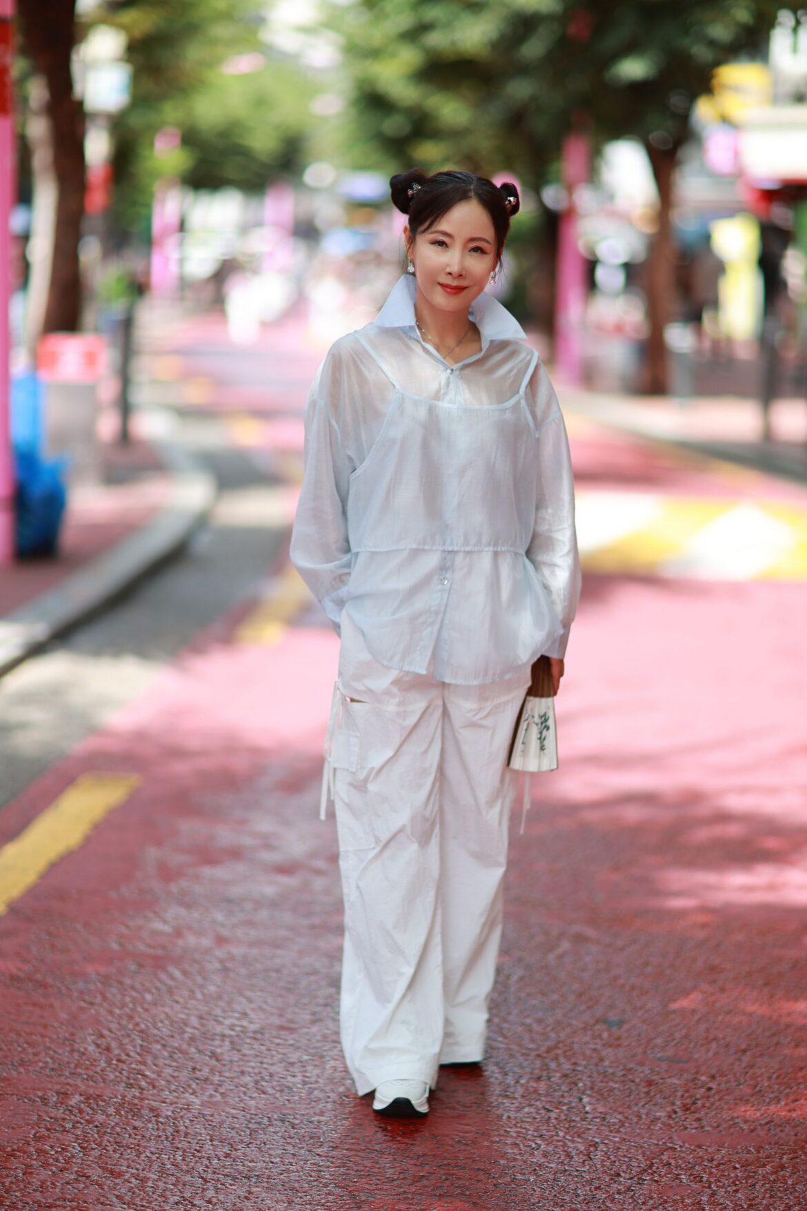 Woman in a fashionable outfit walking a colorful Seoul street