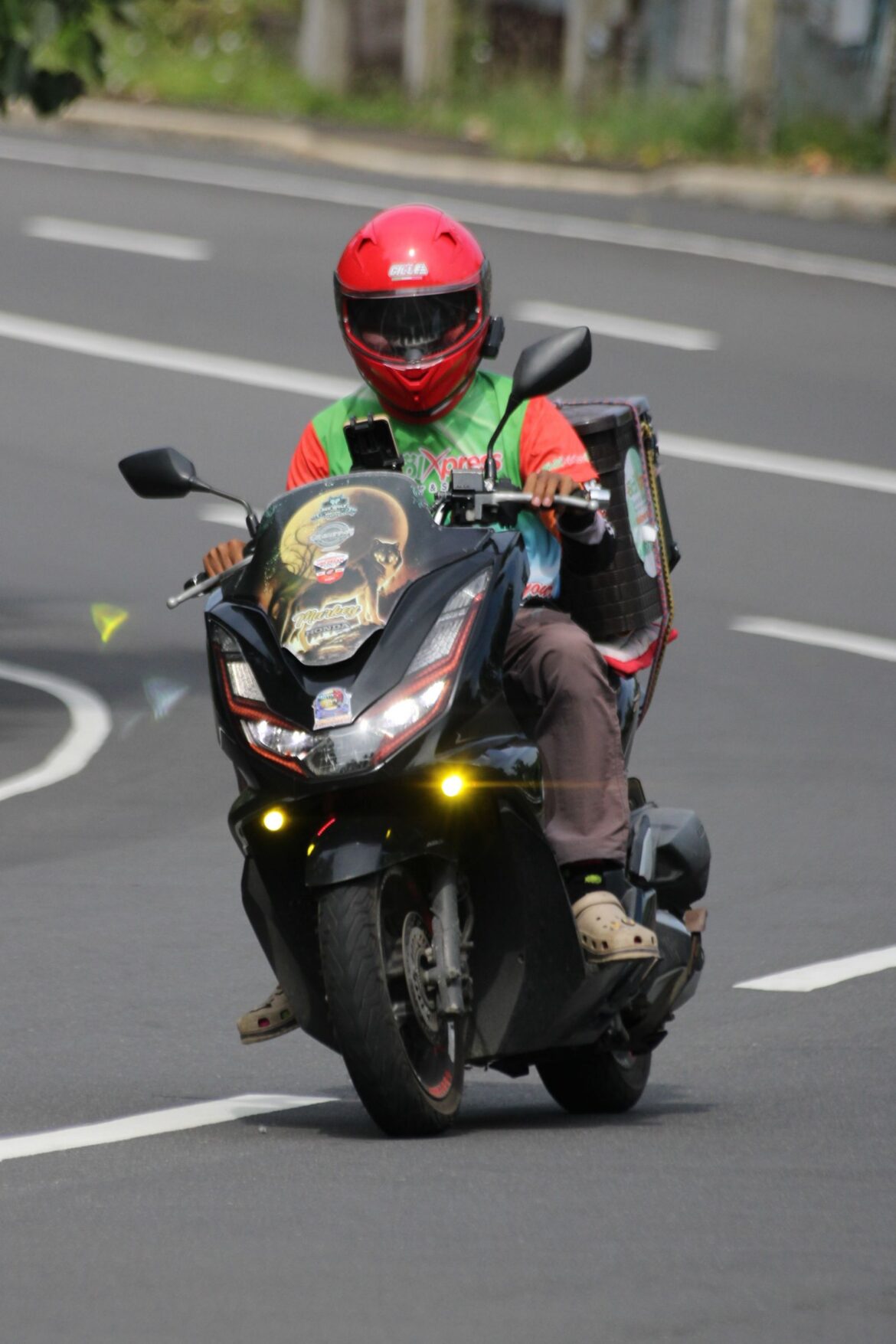 A motorcyclist delivering food on a city street