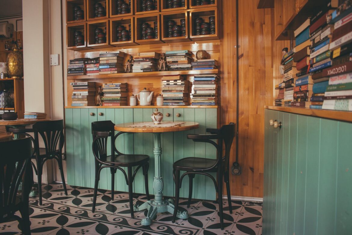 Warm cafe interior featuring wooden bookshelves and teal decor perfect reading nook