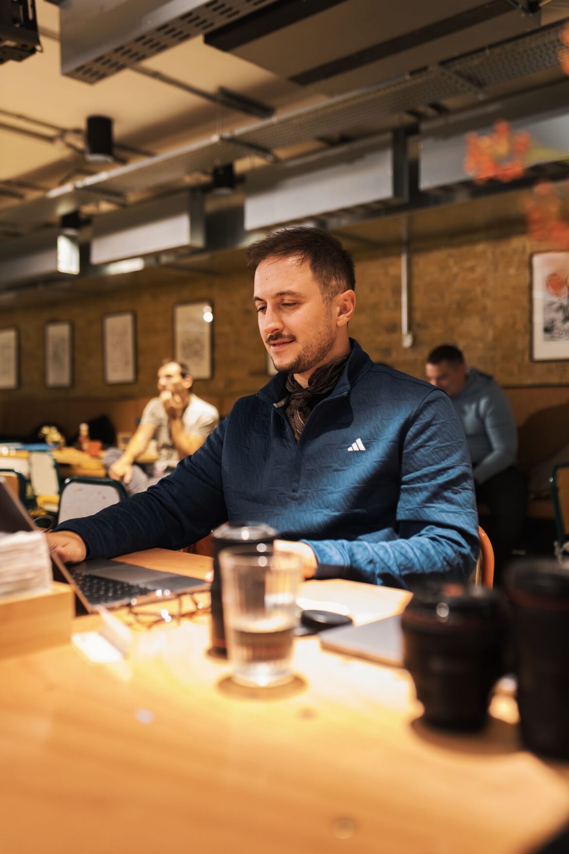 A person working on a laptop in a modern cafe