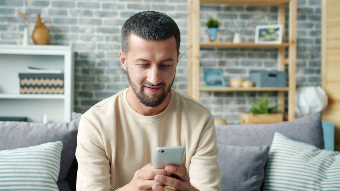 A man relaxing indoors using a smartphone
