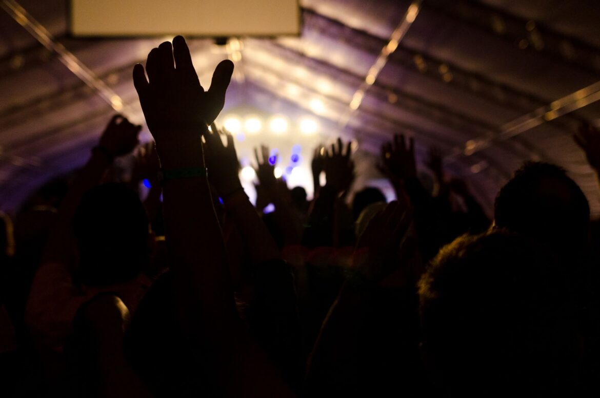 Concert fans cheering with hands raised