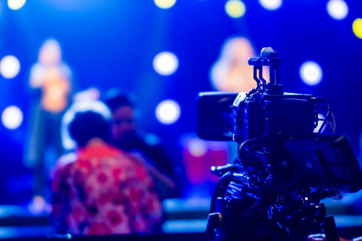 Video camera filming vibrant concert stage