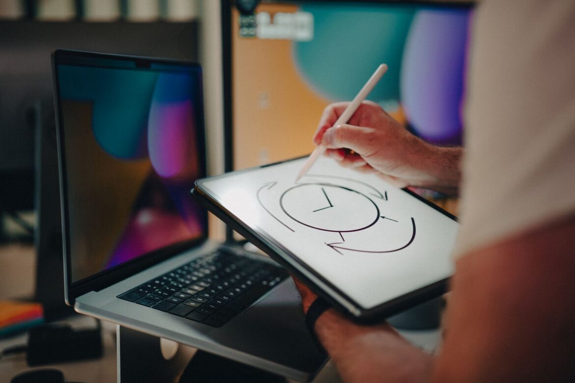 Person using a stylus on a graphic tablet for design in a modern office setting