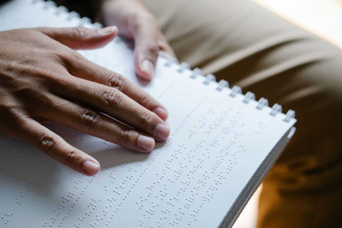 Hands reading braille text