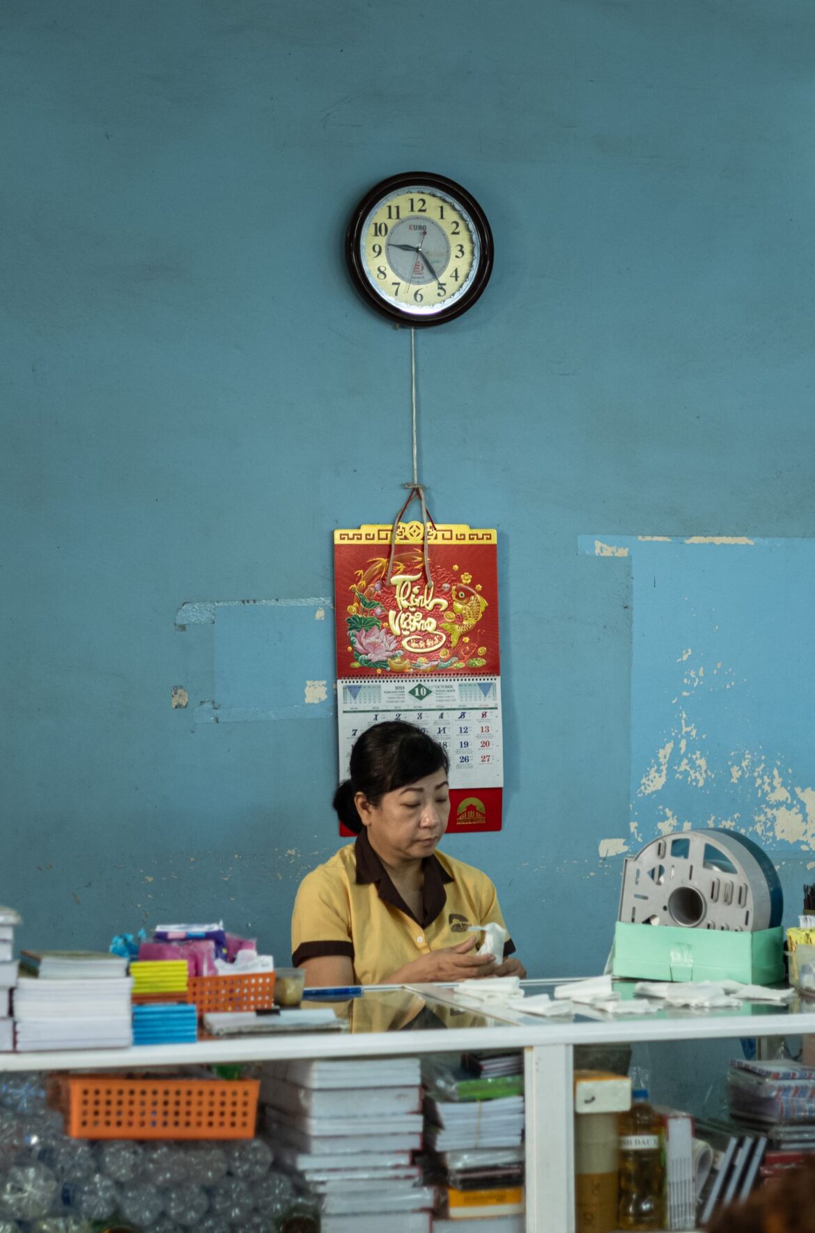 Office worker near a wall clock, representing Korea subsidizing a 4.5-day workweek for small businesses