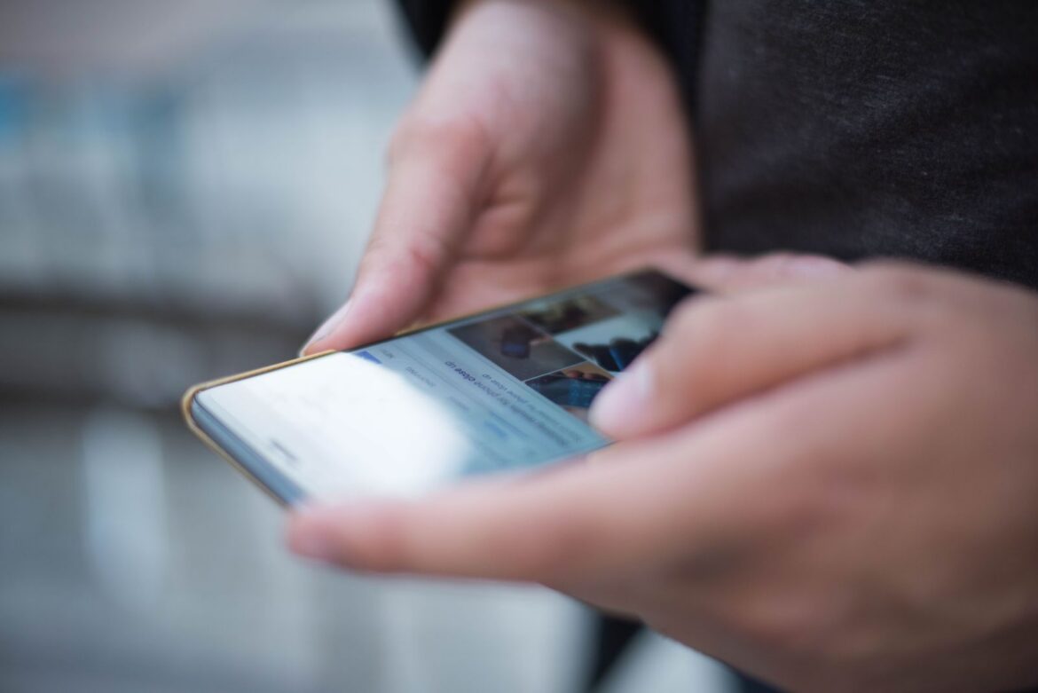 Smartphone browsing, representing Korea new fake news law affecting online platforms