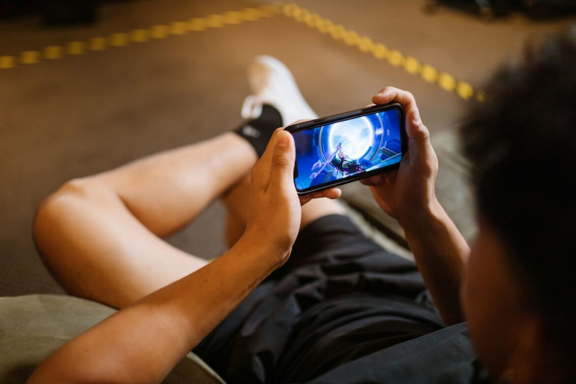 Person playing a mobile game on smartphone, representing Korean mobile MMORPG global growth