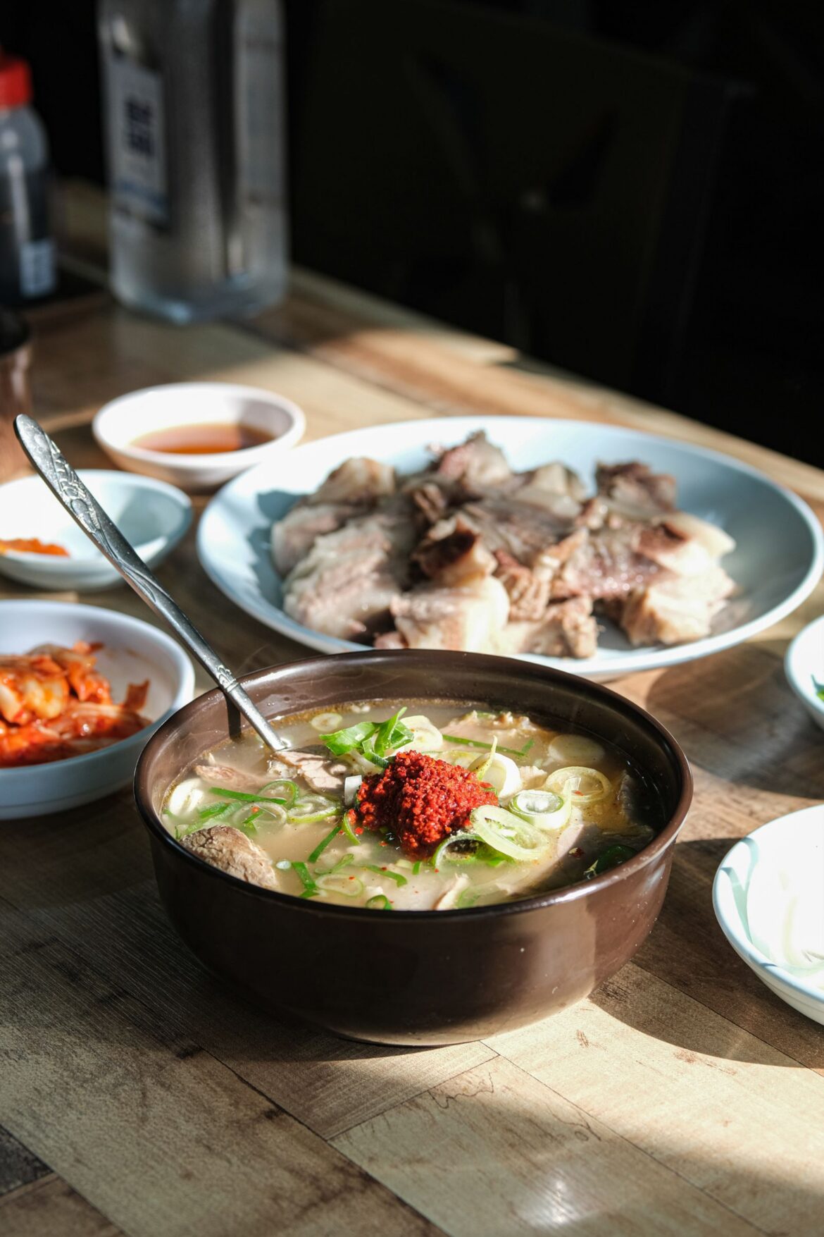 Delicious Korean beef soup served with traditional sides on a wooden table