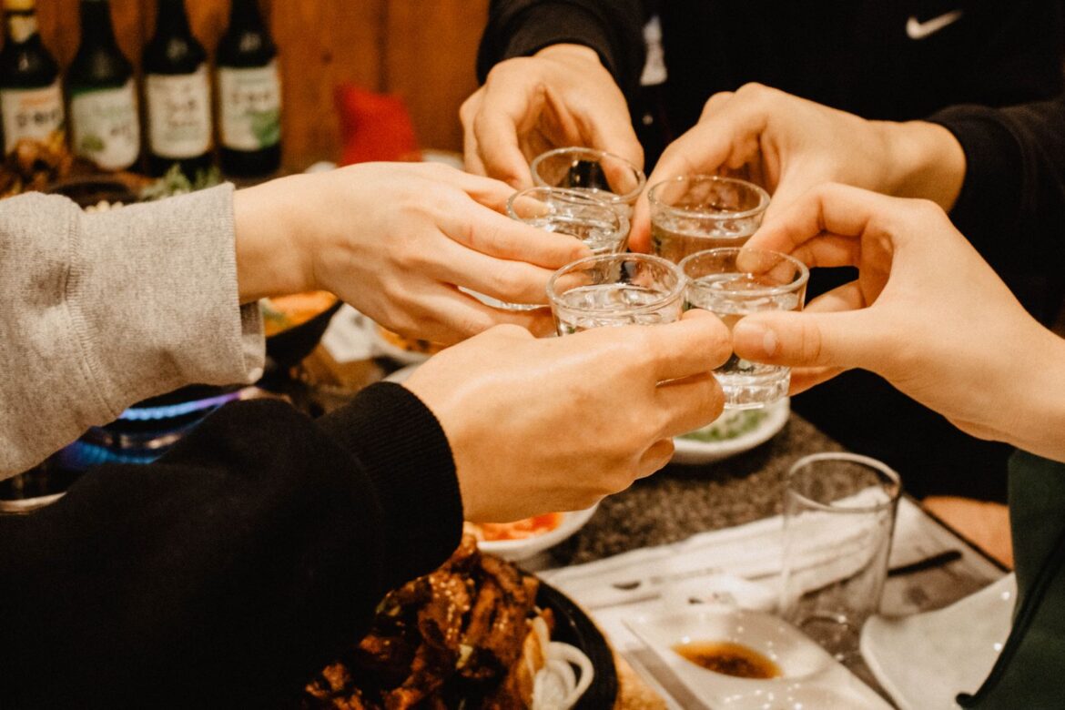 Friends clinking soju glasses in Korea