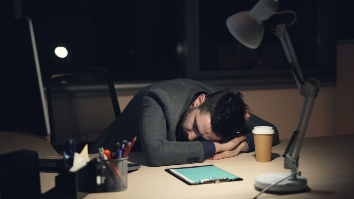 An exhausted worker sleeping at a desk