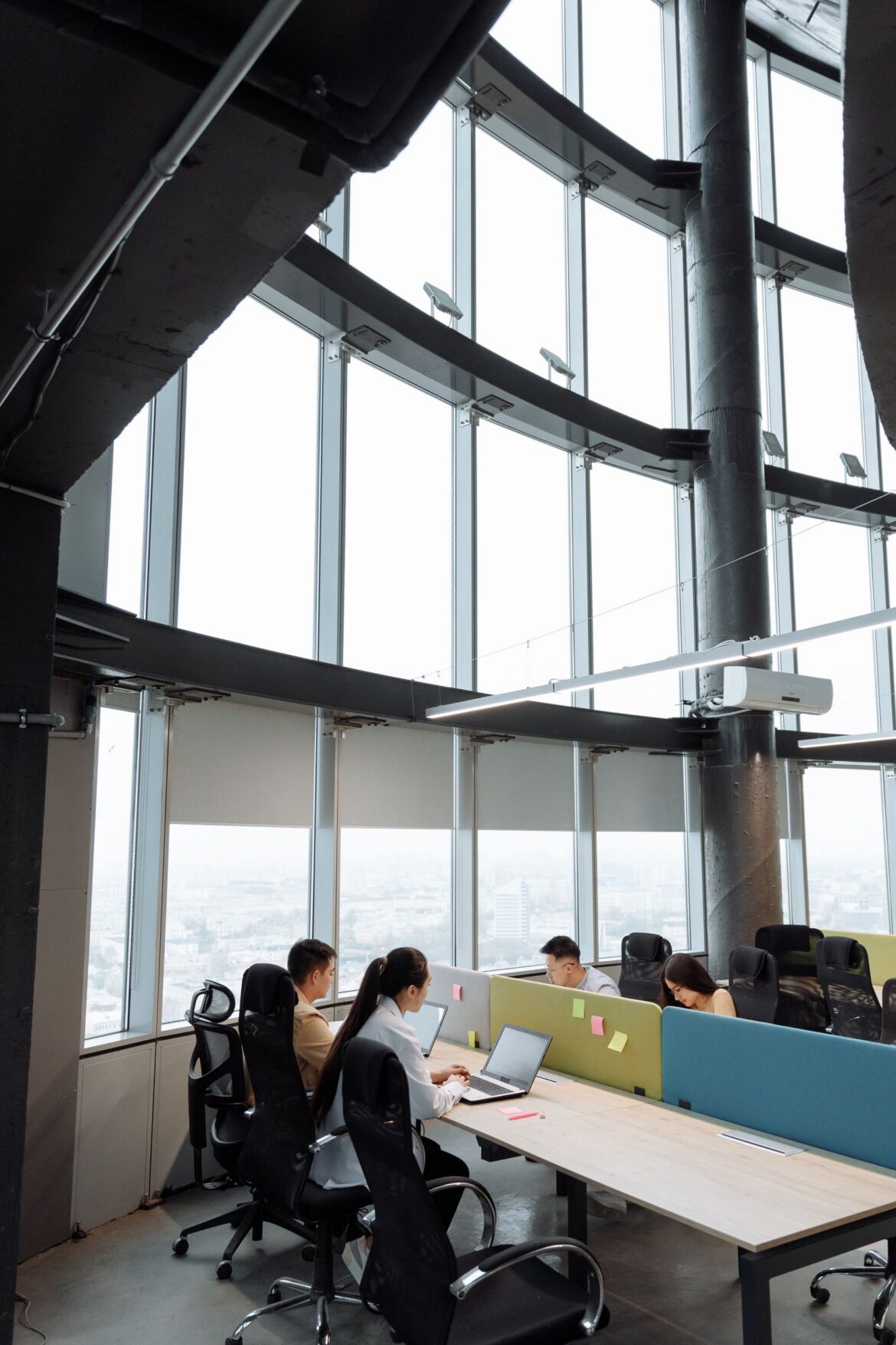 Contemporary office space with employees working on laptops in high-rise building