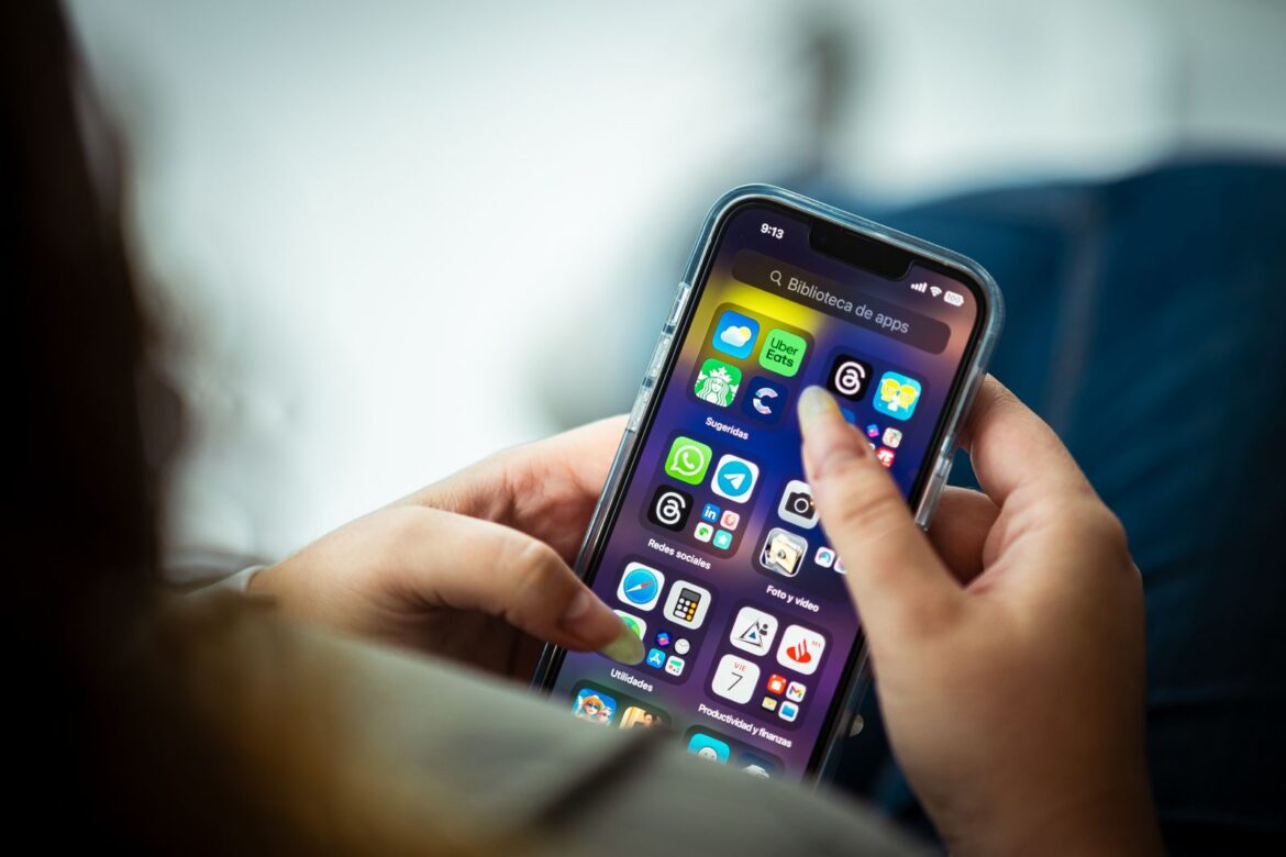 A person holding a smartphone with apps