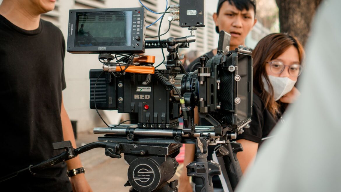 Close-up of a professional film camera setup with crew on outdoor set