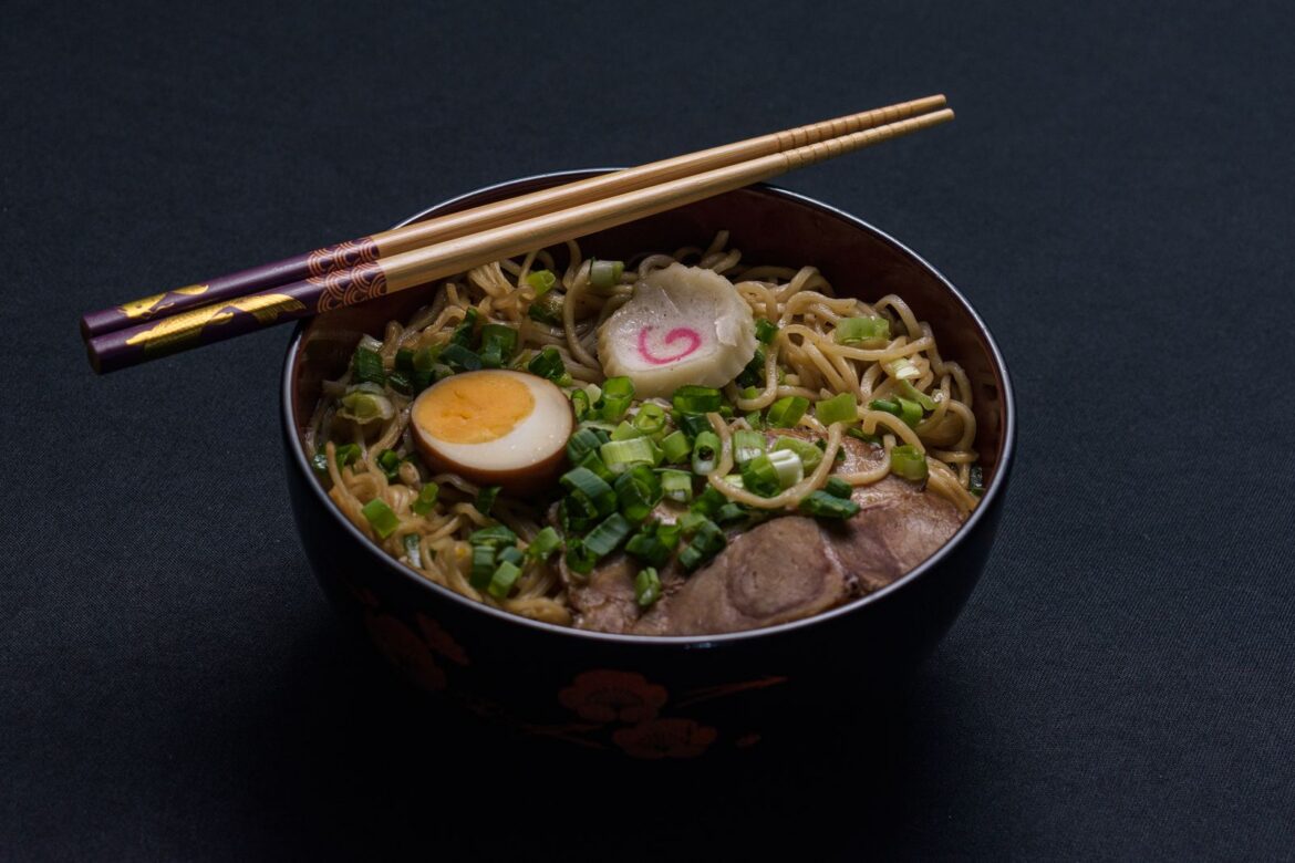 A bowl of ramen noodles with chopsticks