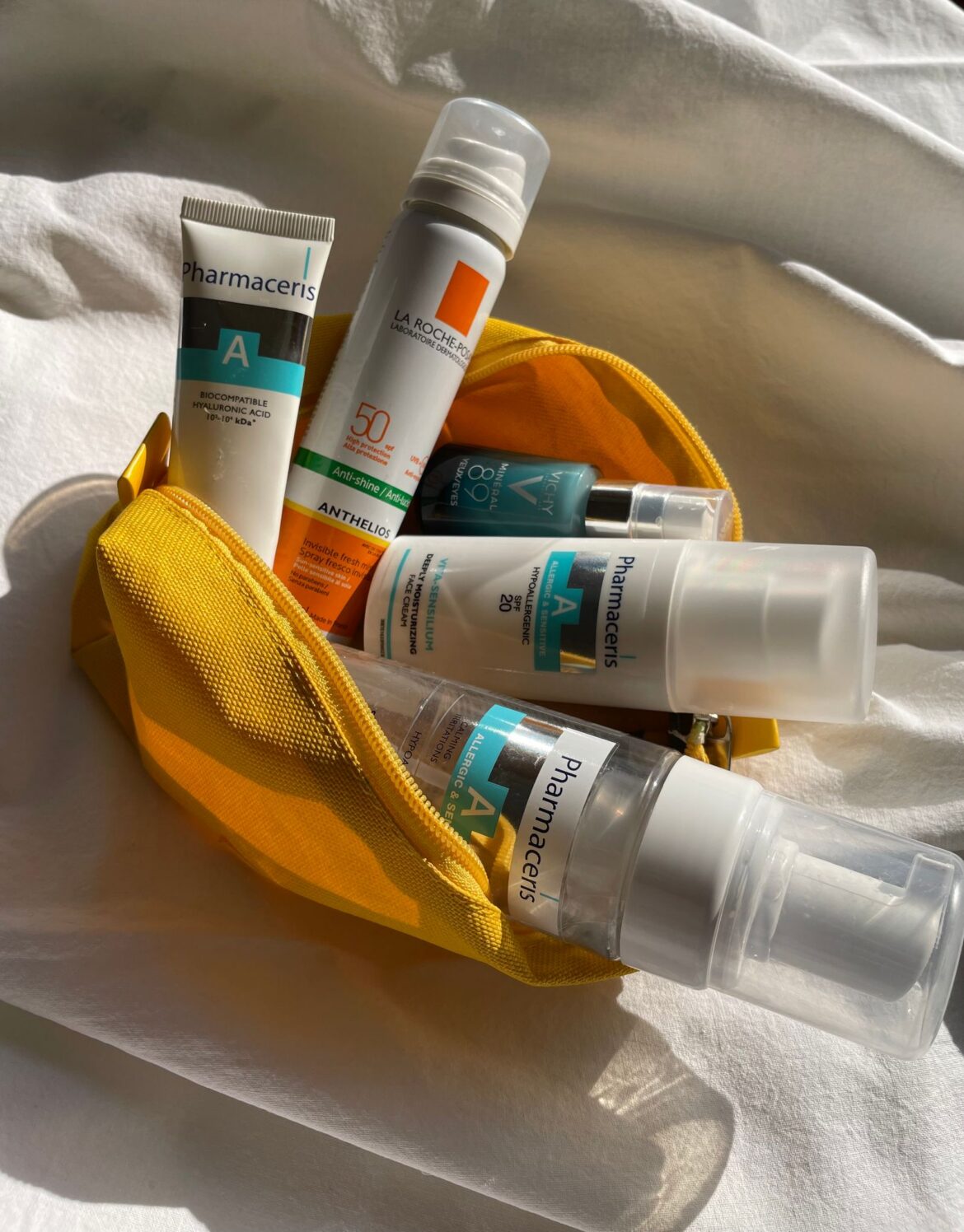 Assorted skincare products in yellow pouch